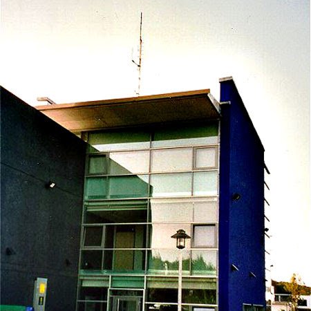 Teil eines Gebäudes mit einer blauen außen Wand und einer großen Fensterfront